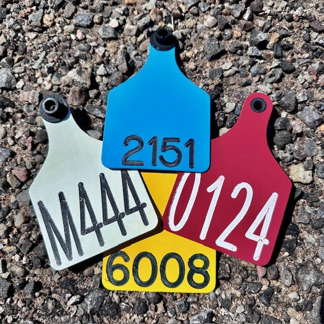 Custom ear tags in various colors that are pre-engraved with ranch management numbers.